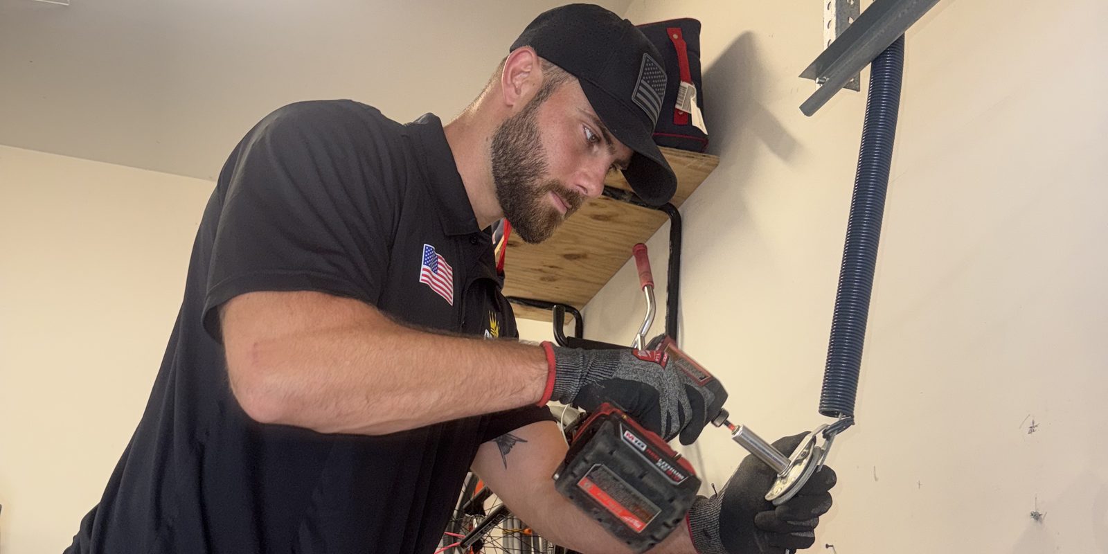 Crown Garage Door technician using a drill on garage door hardware