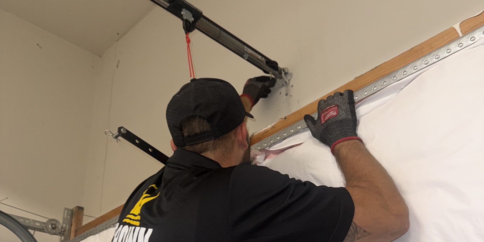 Crown Garage Door technician working at the top of an insulated garage door